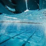 Promienie słońca pod wodą w przejrzystym, niebieskim basenie