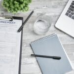 Biurko z laptopem, polisą ubezpieczeniową i notesem