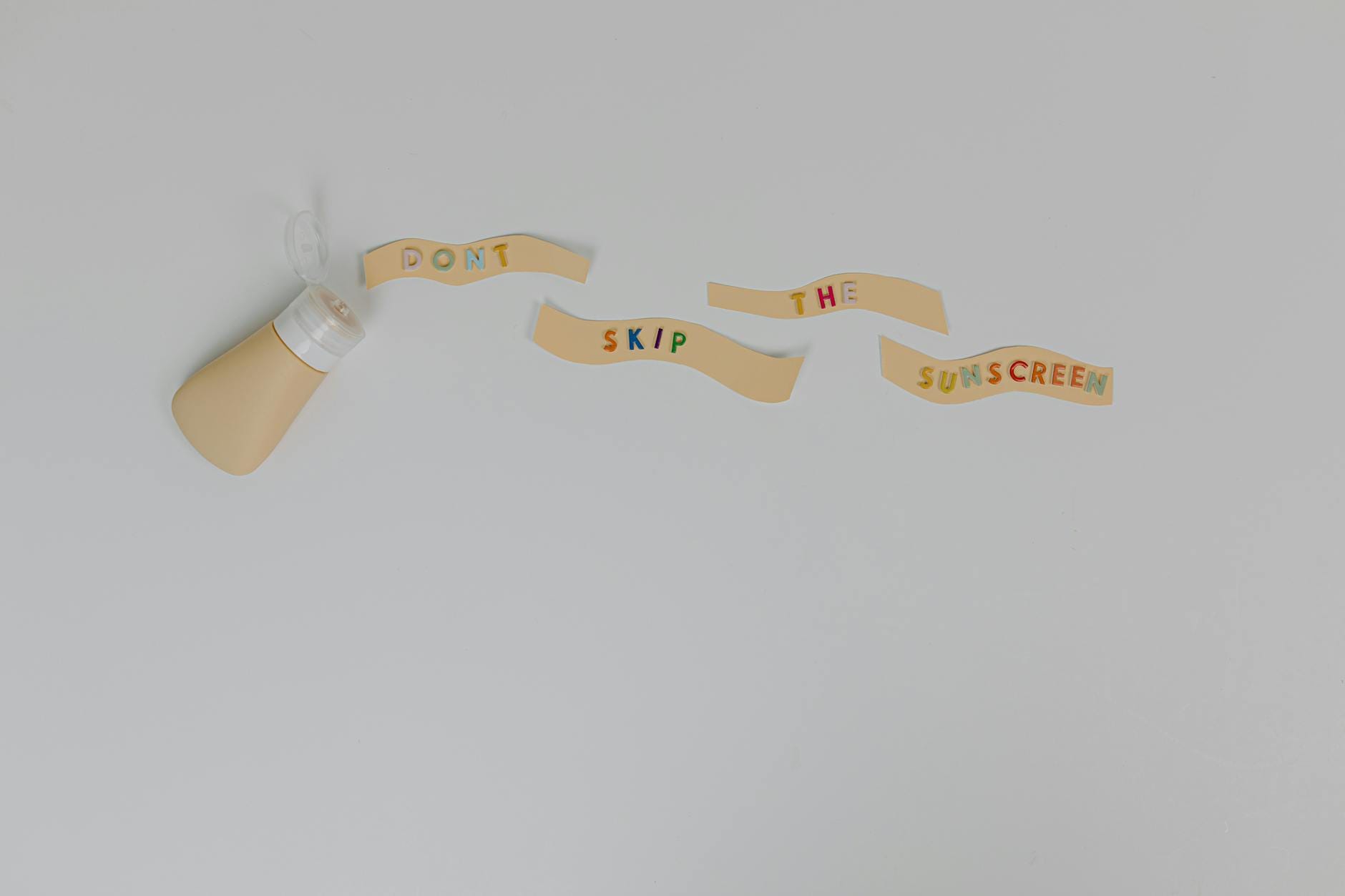 Buteleczka kremu z napisem Don’t Skip the Sunscreen na białym tle