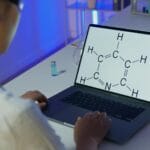 Chemik analizuje wzór chemiczny na ekranie laptopa w laboratorium