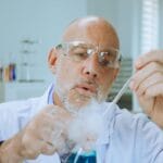 Chemik w fartuchu bada reakcje chemiczne w laboratorium