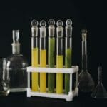 Kolorowe roztwory w probówkach na tle czerni w pracowni chemicznej