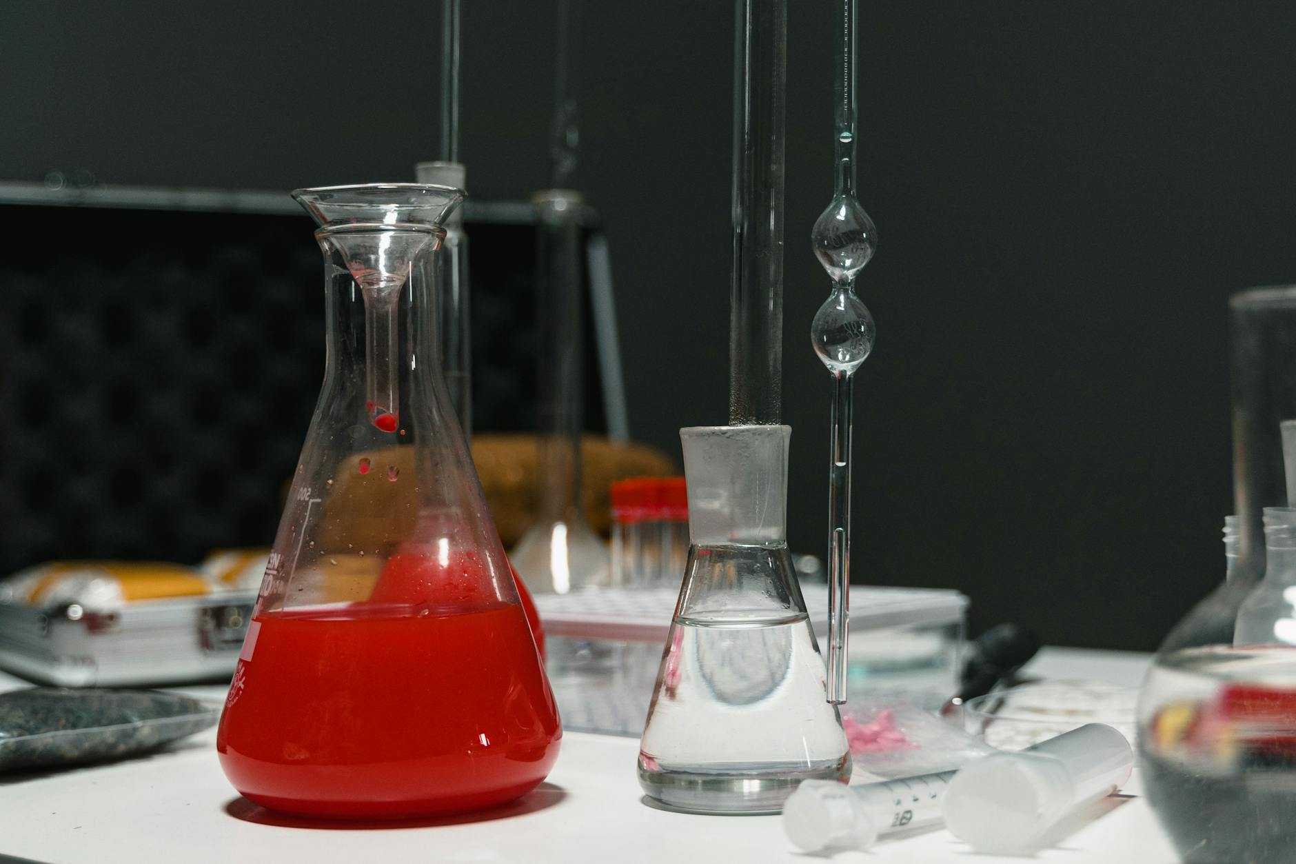 Kolorowe roztwory w szklanej aparaturze laboratoryjnej podczas analizy