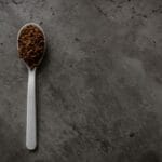 Łyżeczka z kawą rozpuszczalną na ciemnym tle