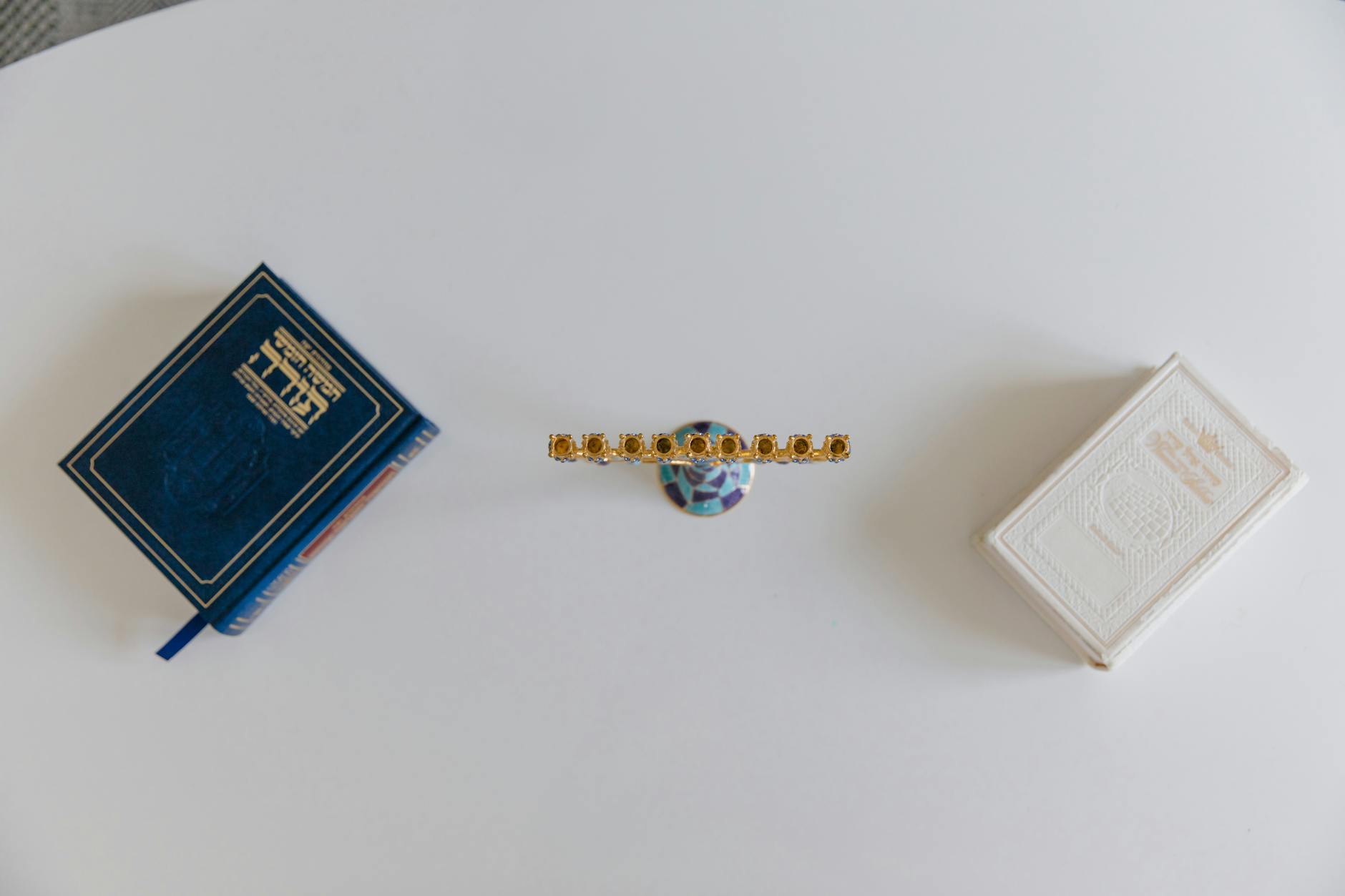 Menora i hebrajskie księgi ułożone na białym tle