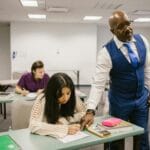 Nauczyciel nadzoruje maturzystów z chemii podczas pisemnego egzaminu