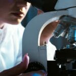 Naukowiec w laboratorium bada próbki pod mikroskopem