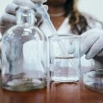 Naukowiec w laboratorium zakrapla ciecz do zlewki