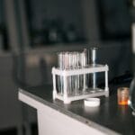 Probówki laboratoryjne i sprzęt na blacie w pracowni chemicznej