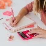 Uczeń liczy zadania z chemii na różowym kalkulatorze w zeszycie