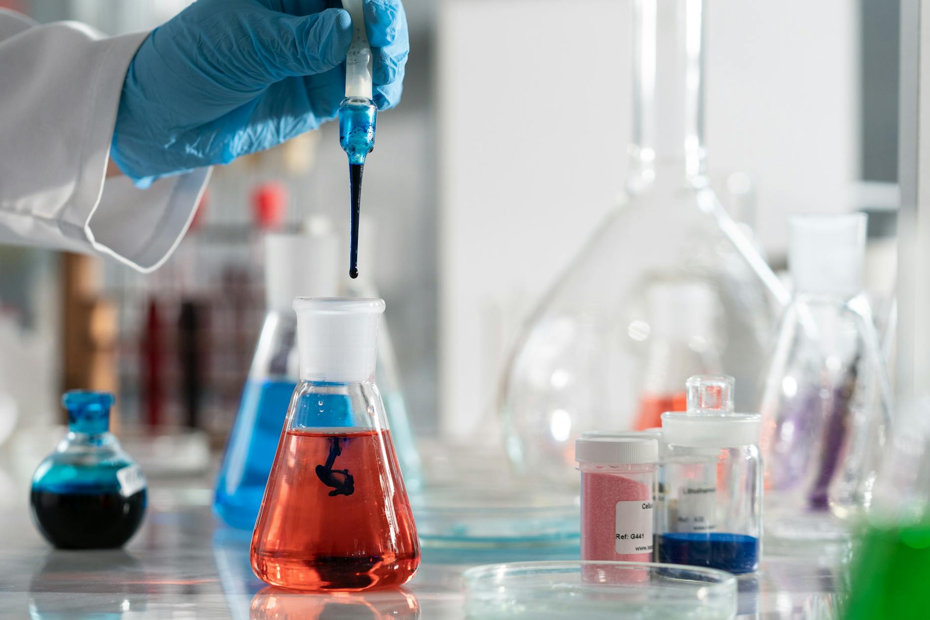 Po co są katalizatory i dlaczego nie zmieniają położenia równowagi? Odpowiadamy na Wasze pytania z lekcji i laboratorium Chemik wykonuje doświadczenie z kolorowymi roztworami w laboratorium