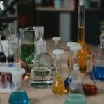 Kolorowe roztwory chemiczne w szklanych naczyniach na stole laboratoryjnym