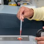 Laborant w nowoczesnym laboratorium odmierzający ciecz pipetą